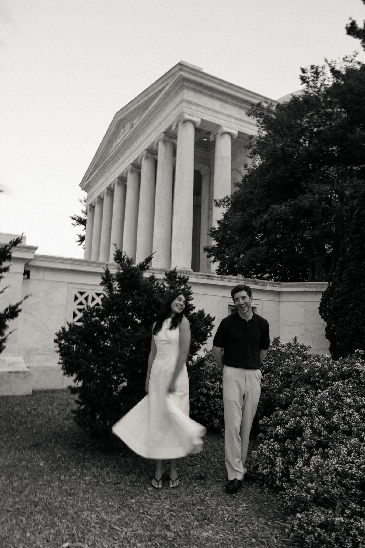 Filiz twirling her white dress beside Joseph, both laughing, in the garden below the Jefferson Memorial